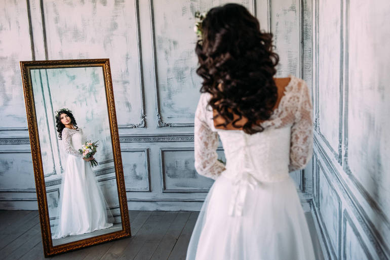 Разглядывать себя в свадебном платье 